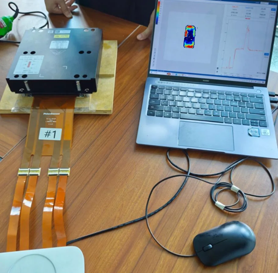 Sensing array laid between a heatsink and its mounting plate, connected to a data collector and a laptop